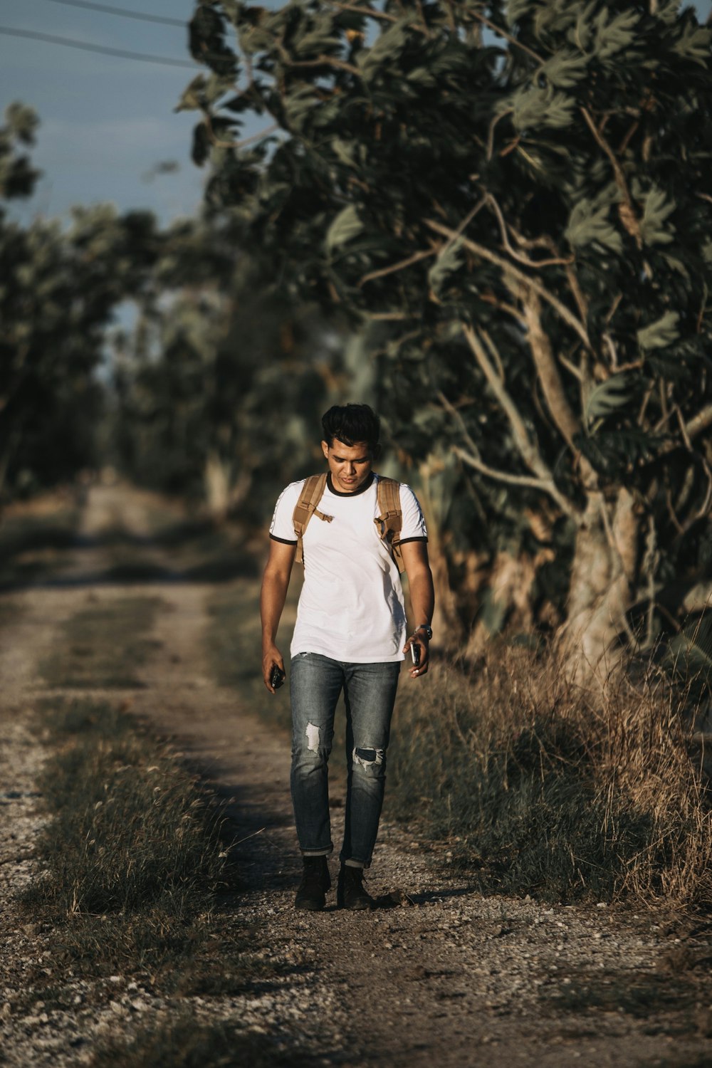 man walking on dirt road