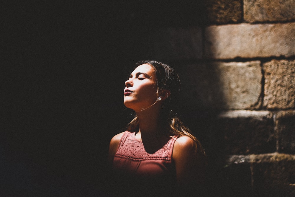 selective focus photography of woman standing against wall