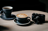 A cozy café scene with steaming cups of coffee and a camera set up for a food photography session.
