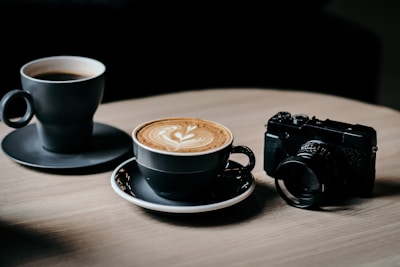 A cozy morning scene with a high-end espresso machine brewing fresh coffee next to a Sony a7 IV camera and a notebook.