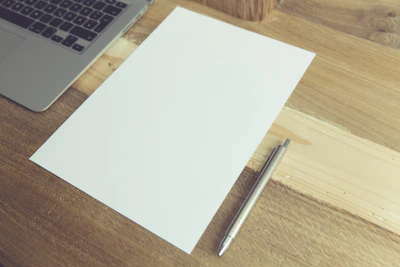 An open portfolio showcasing Larry's writing drafts and notes on a wooden desk