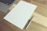 A cozy desk setup with a notebook open to a blank page, a pen resting on top.