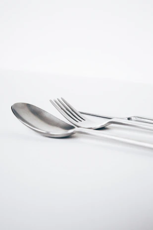 A happy customer using the silverware clip at a beautifully set dining table with soft natural light.