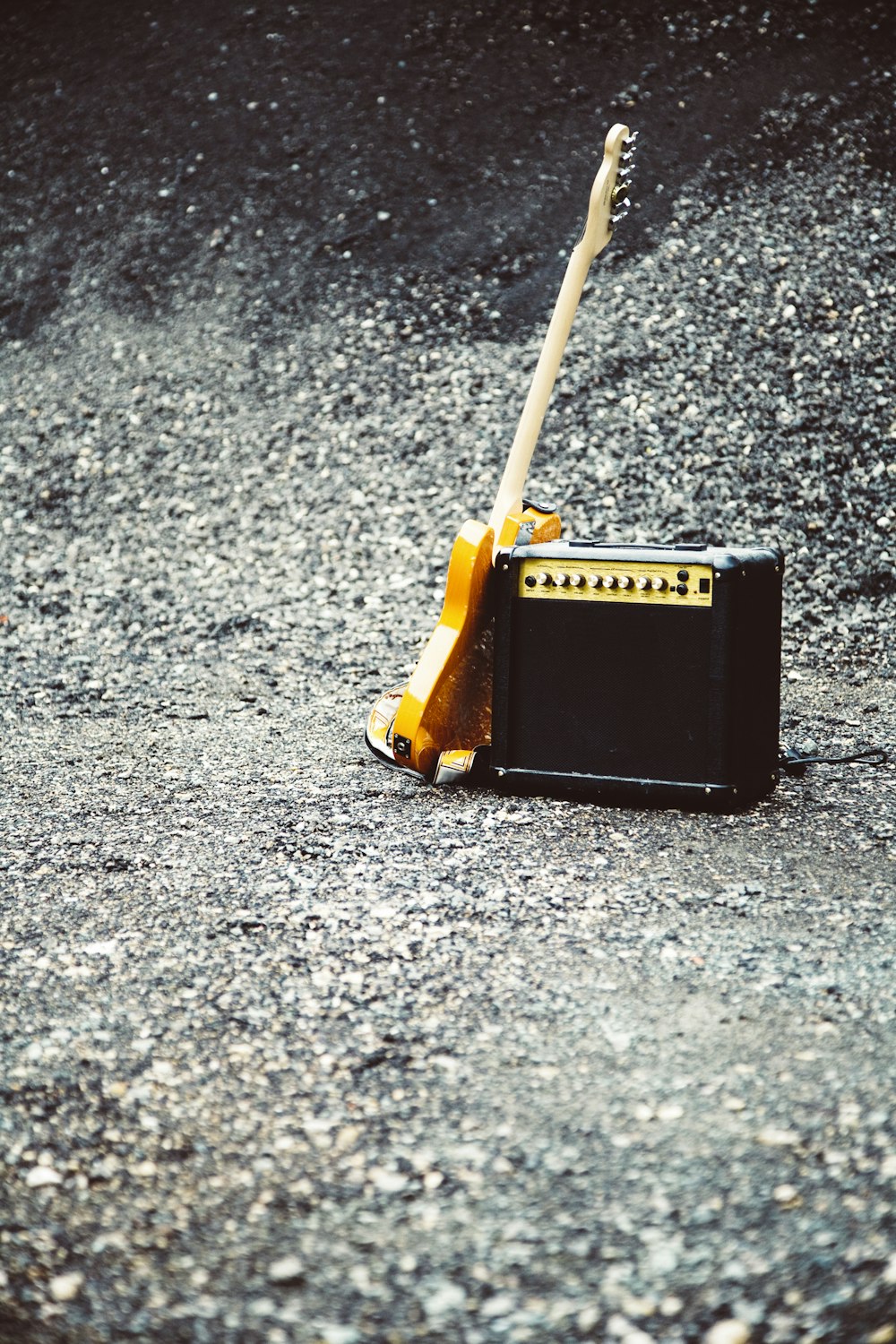 amplificador de guitarra preto e marrom ao lado da guitarra elétrica