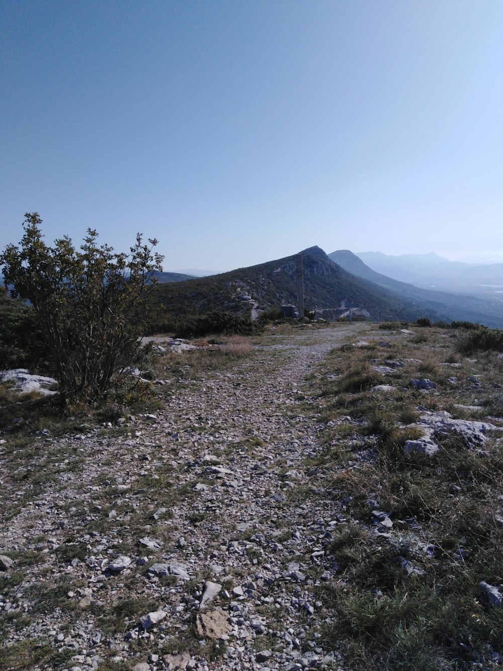 a dirt path on a hill with a mountain in the background