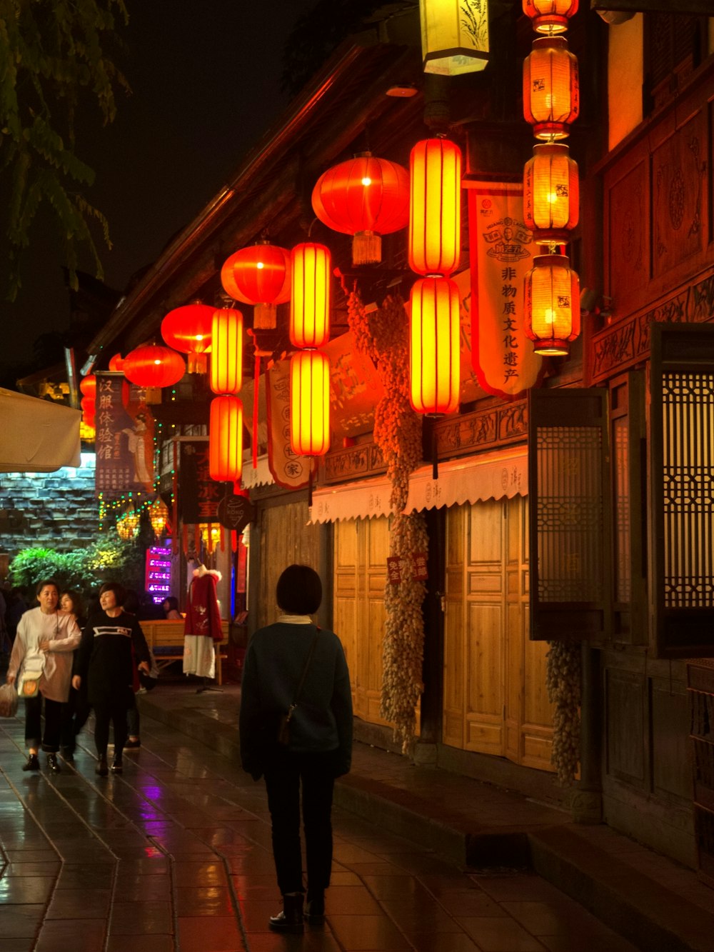 person walking under paper lamps