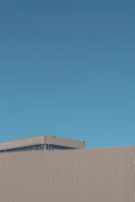 A minimalist Scandinavian-inspired hotel facade against a clear sky.