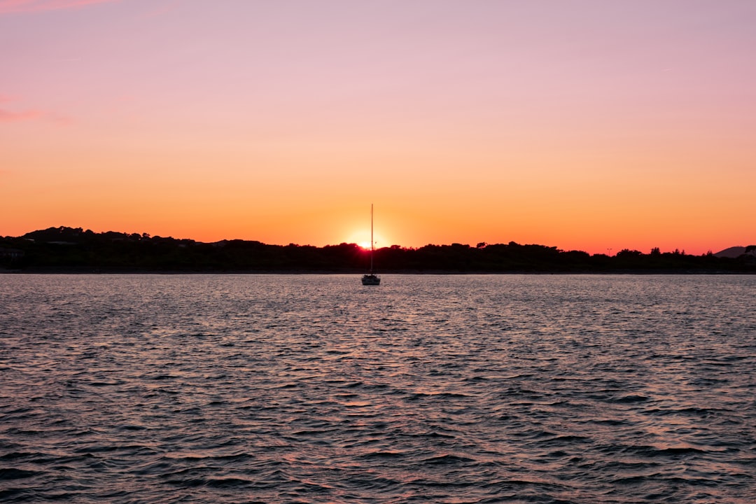 the sun is setting over a body of water,