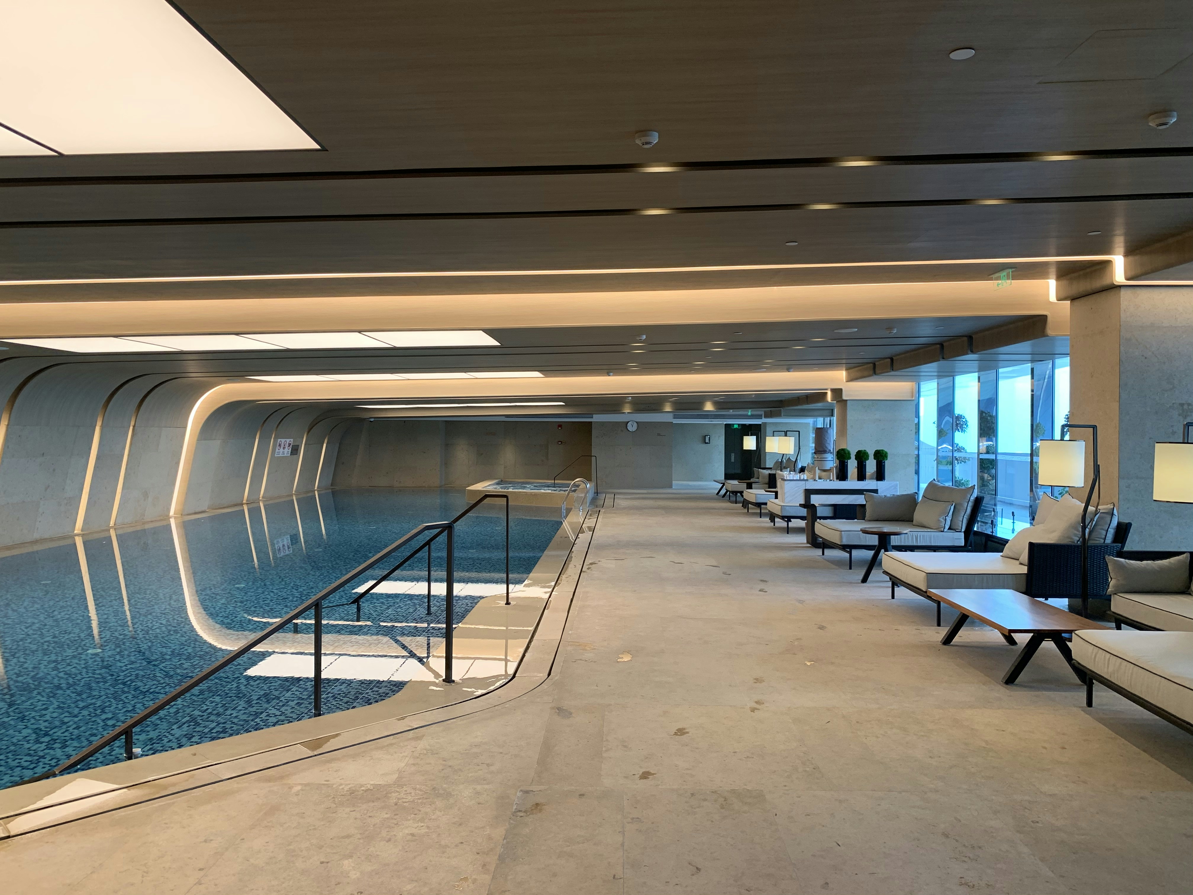 Modern travel workspace with empty lounger chair beside pool
