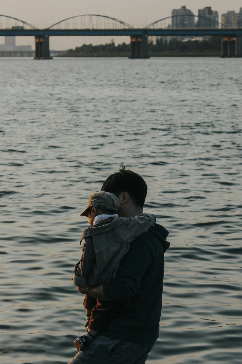 man carrying a baby in the beach