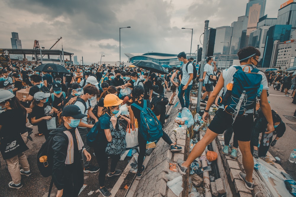 people standing outside buildings wearing face mask during daytime