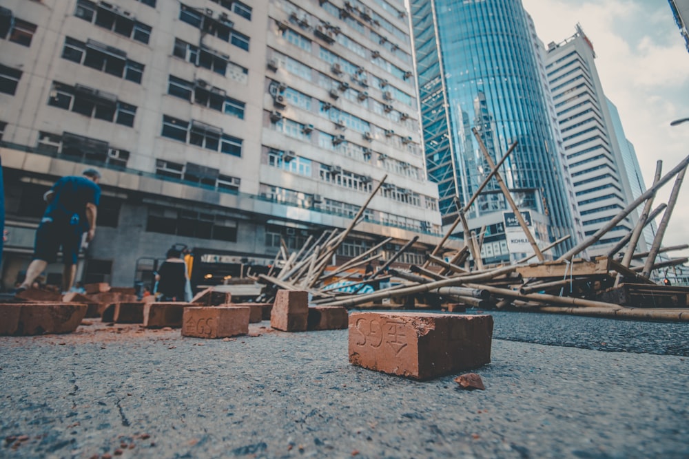 man standing in the street surrounded with wood scraps