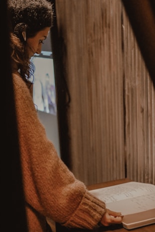 A person calmly listening and taking notes in a cozy, quiet room.
