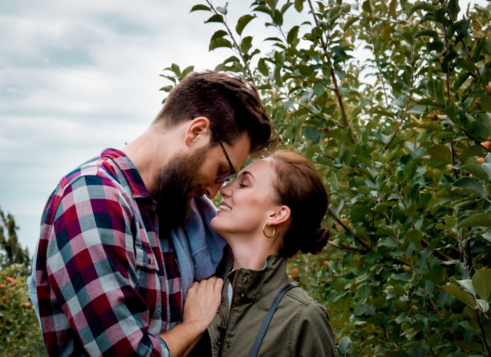 man and woman about to kiss surrounded by plants