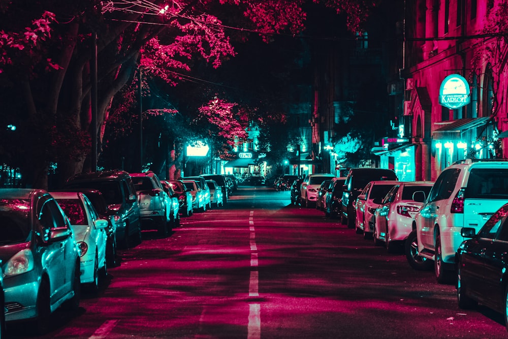 vehicles parked near building and trees during nighttime