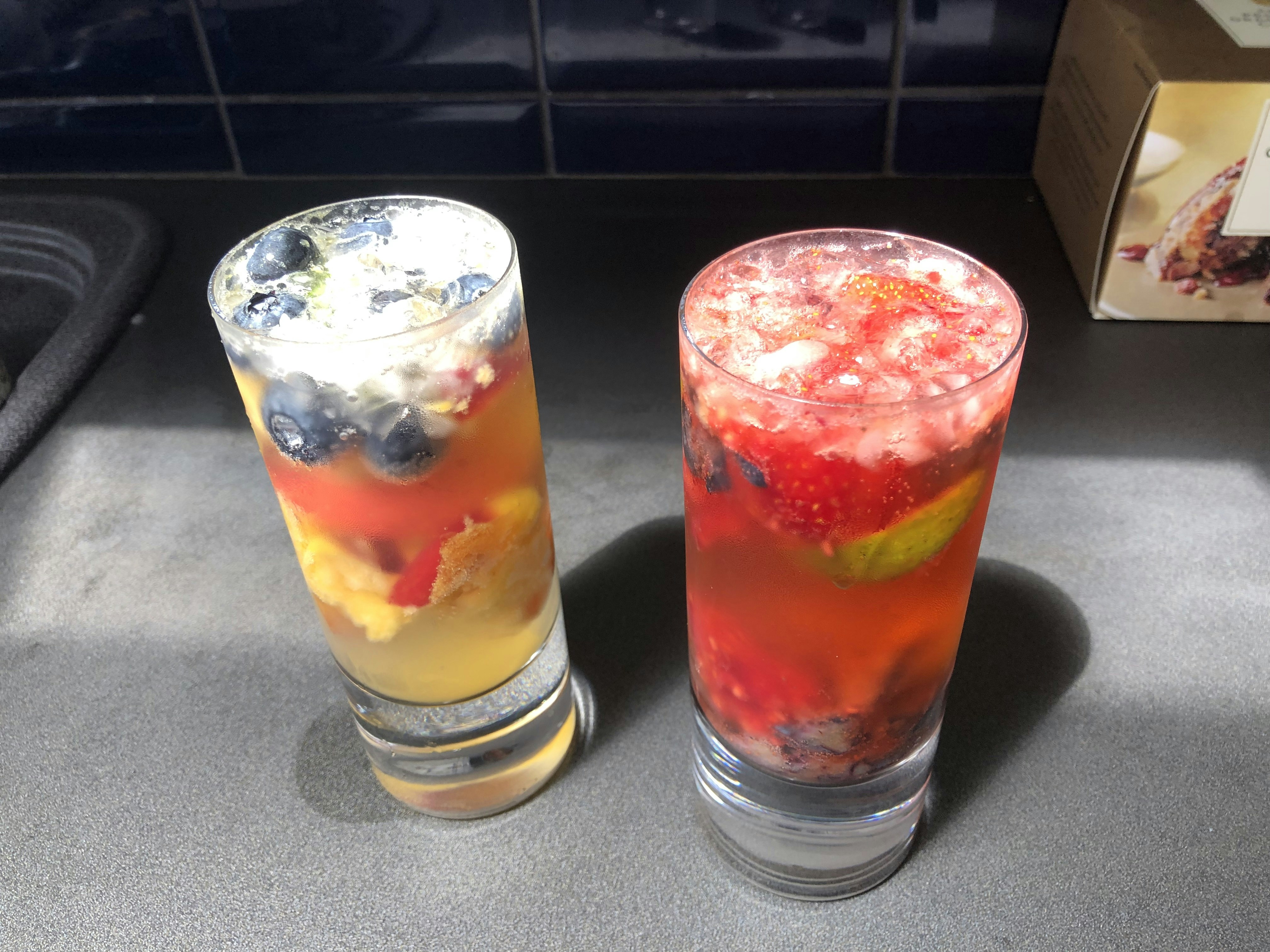 Colorful tropical fruit juices in glasses with fruit garnishes, vibrant orange and yellow