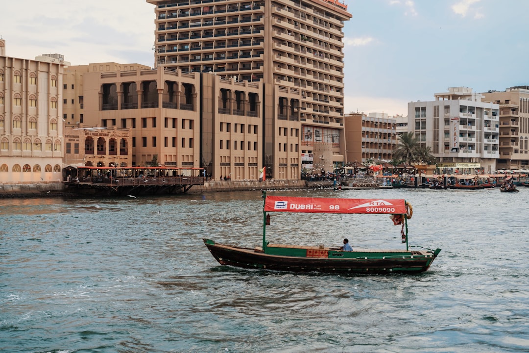 brown and green sailboat sailing near buildings