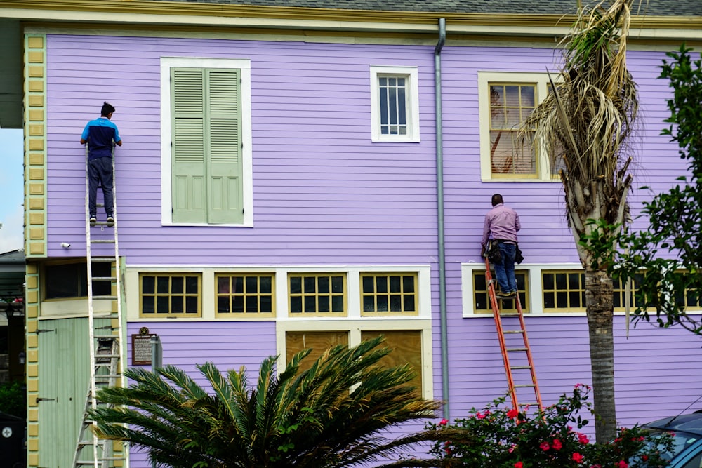 zwei Männer in Leiter an der Wand