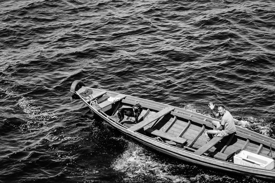 greyscale photography of man riding on boat, Dog & Man