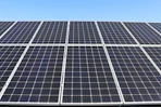 Close-up of high-quality solar panels gleaming under a clear blue sky, symbolizing clean energy.