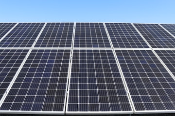 Close-up of solar panels gleaming under a clear blue sky, showcasing their sleek, efficient design.