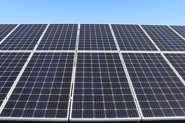 Close-up of solar panels reflecting sunlight in a clean industrial field.