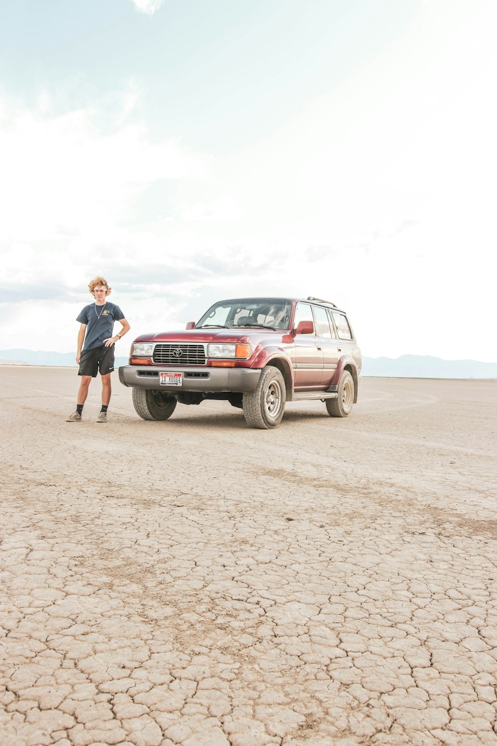 man standing beside SUV