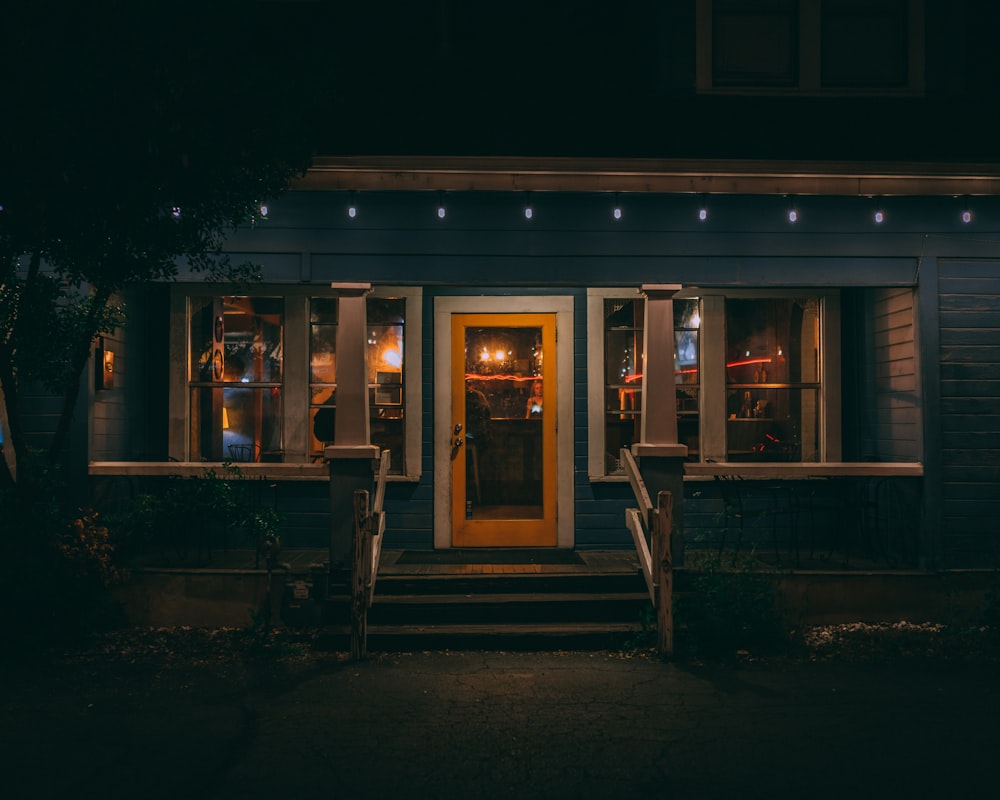 blue painted house with turned-on lights