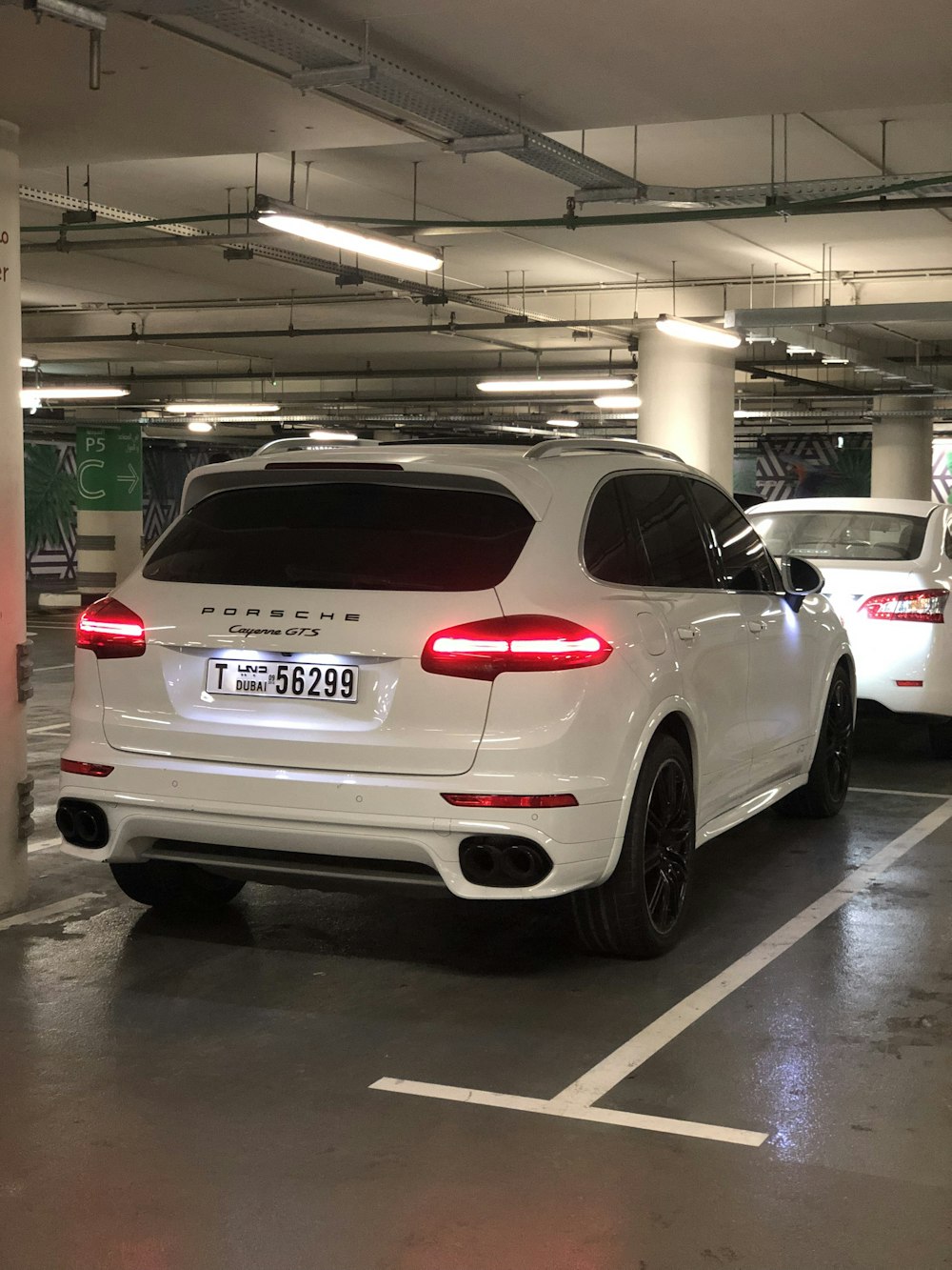 parked white Porsche SUV inside indoor parking lot