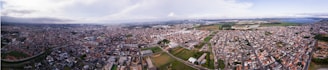 A panoramic view of multiple autonomous robots navigating together in an urban outdoor setting under clear skies.