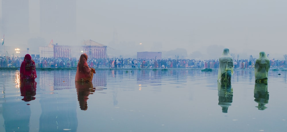 four person standing in body of water