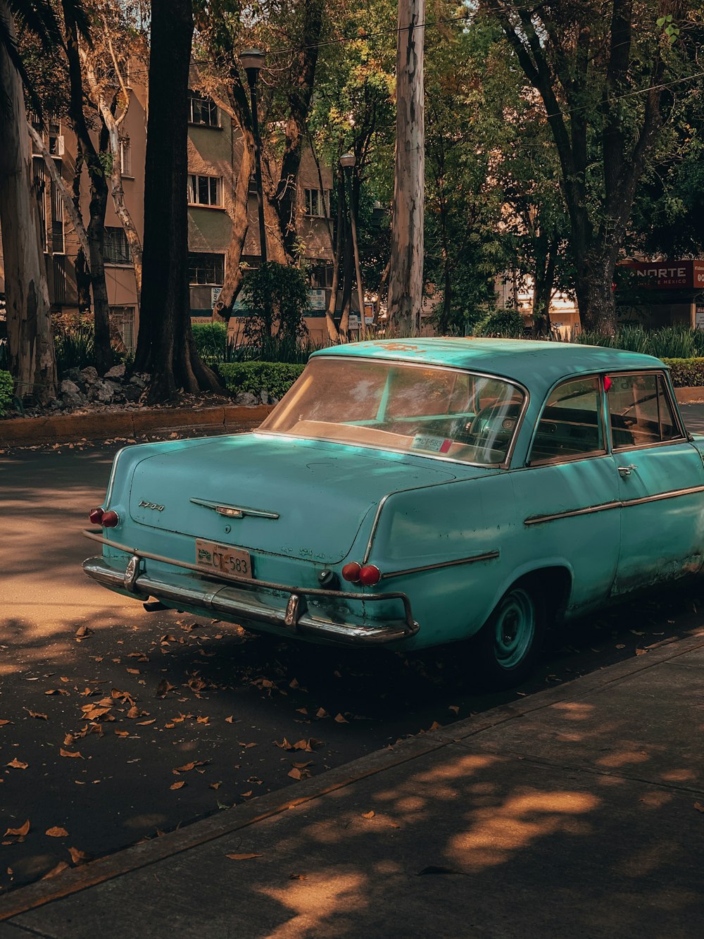 parked teal sedan beside curb