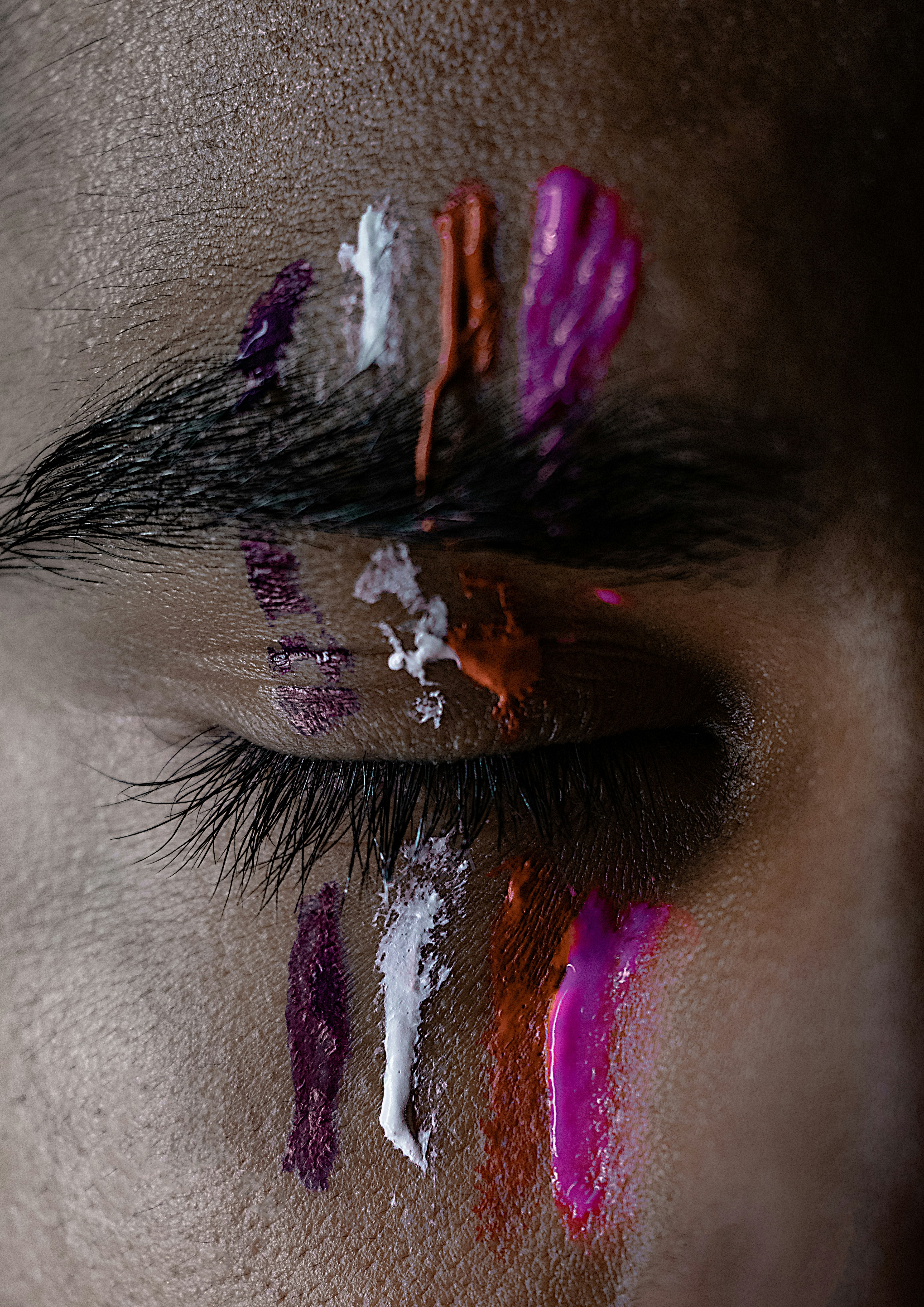 pink, red, white, and purple paints on man's eye