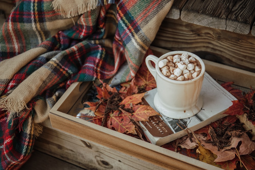 Tasse en céramique blanche sur livre