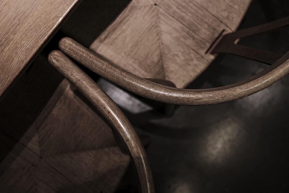 a close up of a wooden chair with a black leather seat