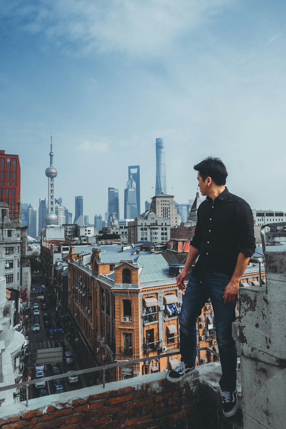 man in black dress shirt standing on wall