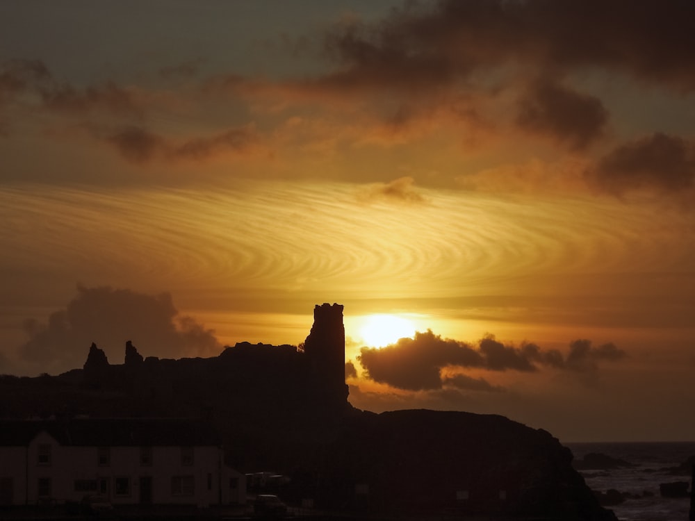 silhouette of house and mountain during golden hour