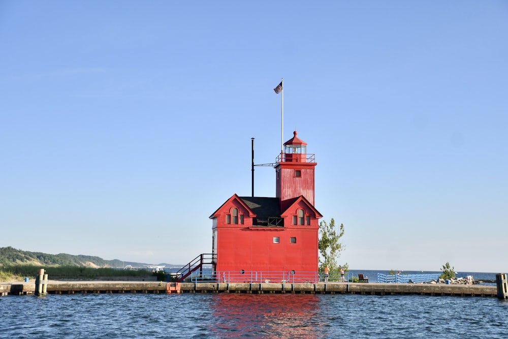 red concrete building with tower beside body of water