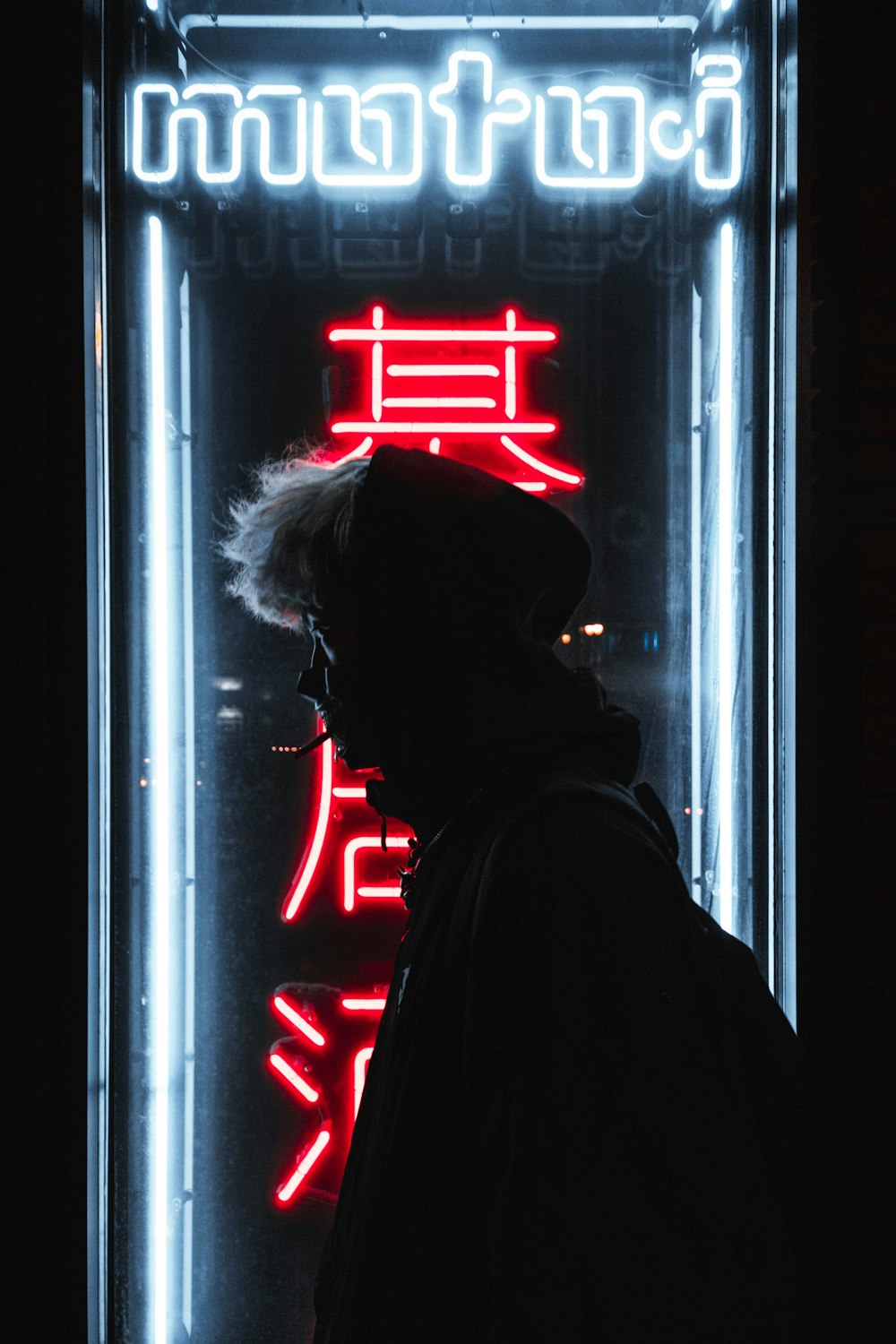 silhouette of person standing in front of neon sign
