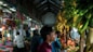 man in red shirt standing near green banana fruit during daytime