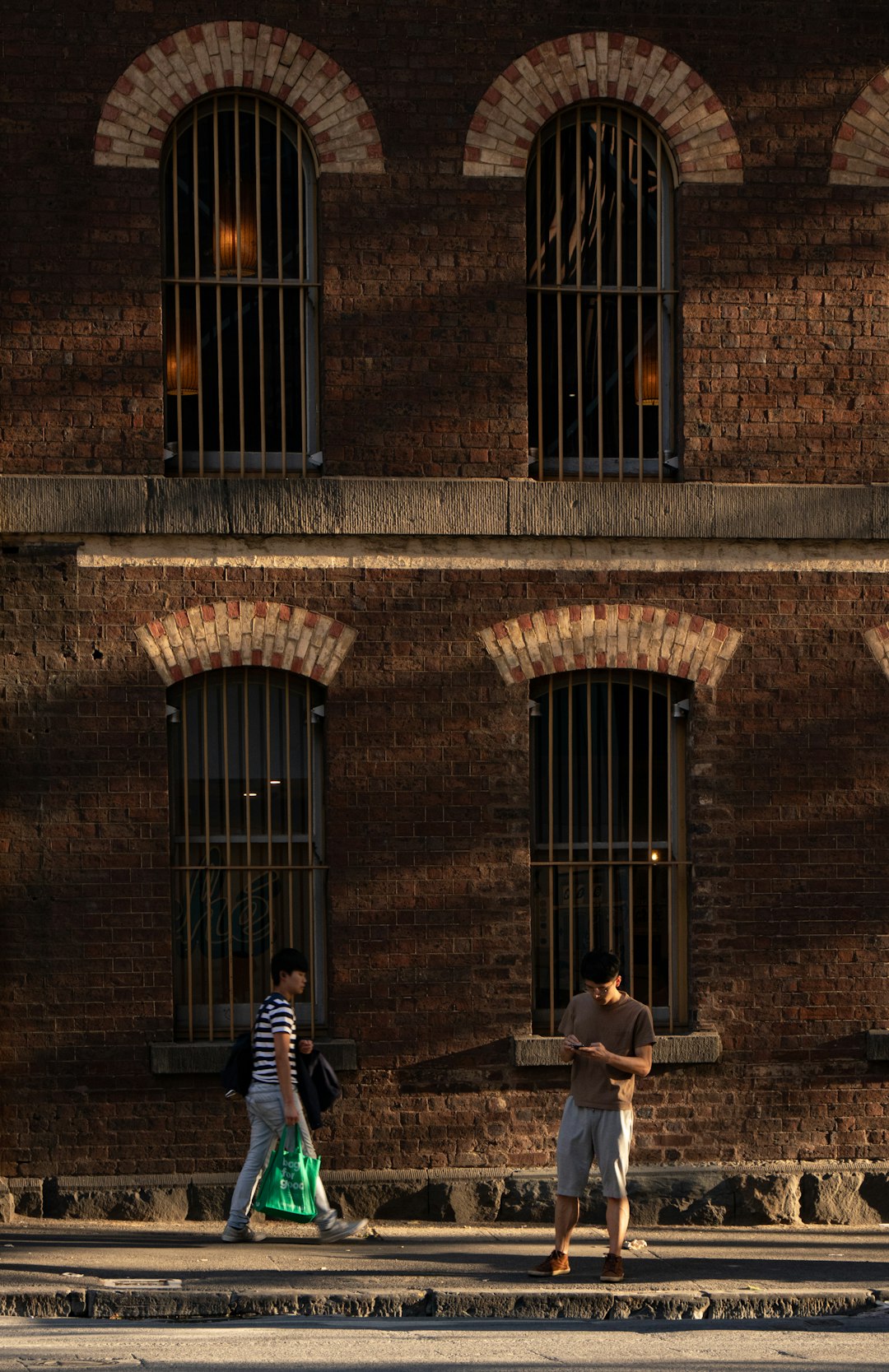 two men standing near brown building