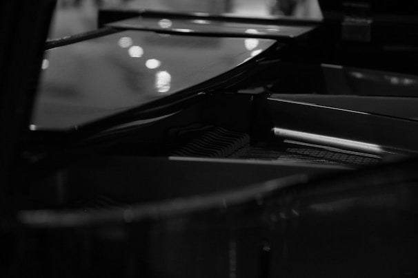 Black and white photo of a grand piano keyboard with soft natural light highlighting the keys.