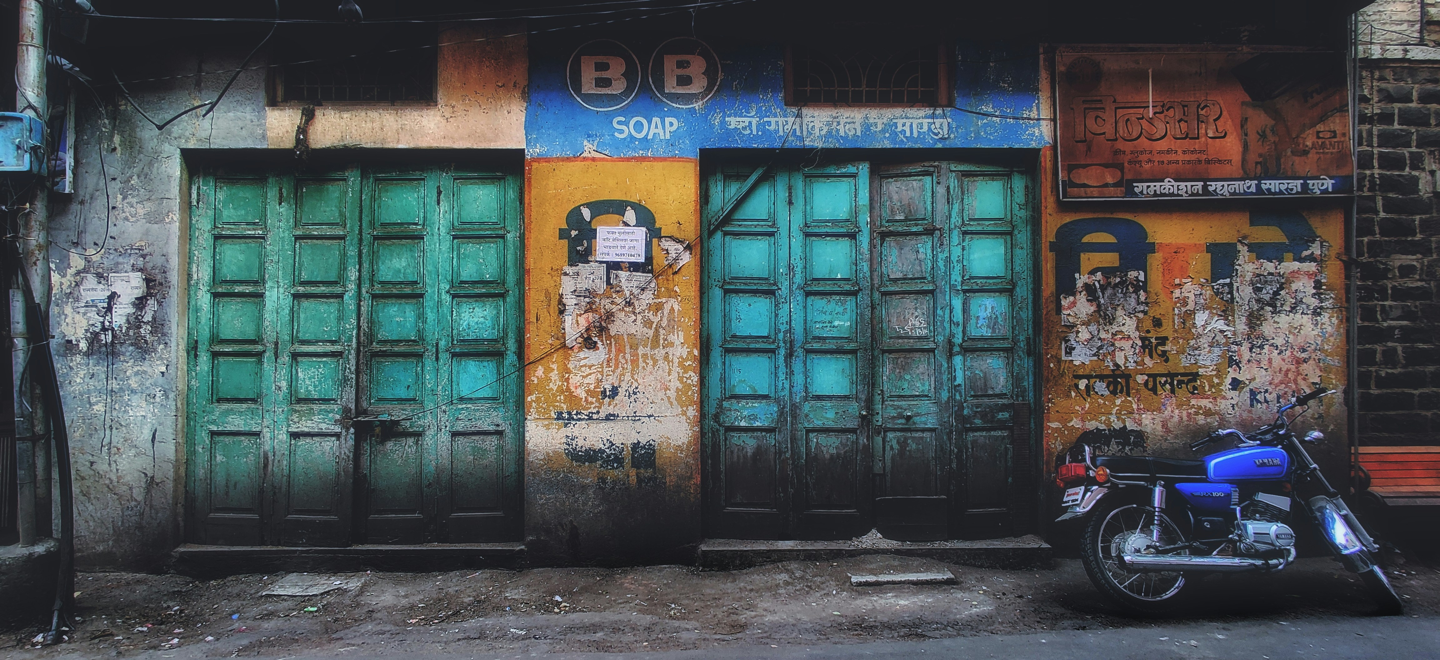 black standard motorcycle parked beside wall