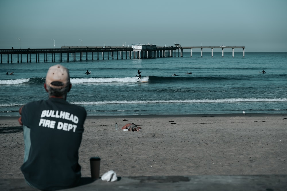 man sitting in front of sea