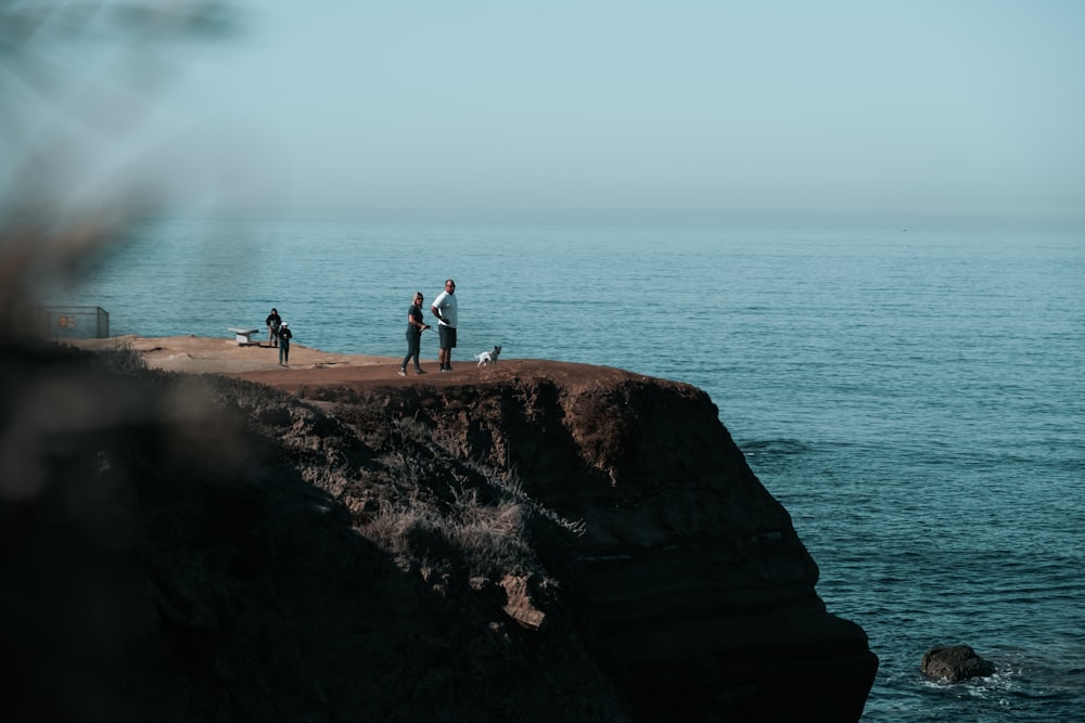 people on cliff during daytime