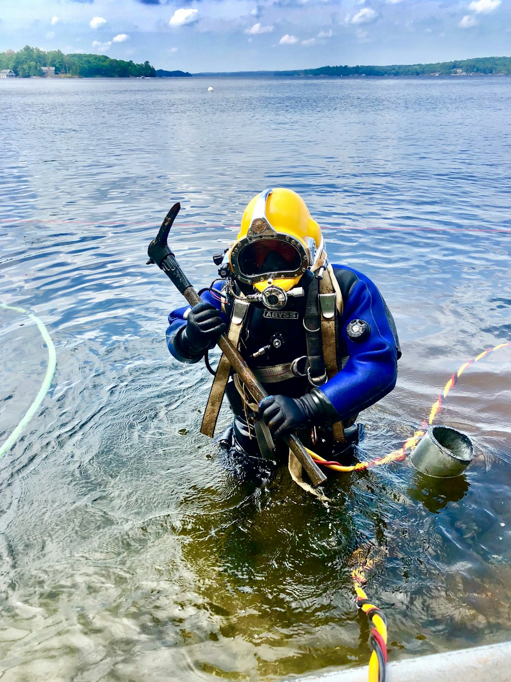 person holding brown tool on body of water during daytime