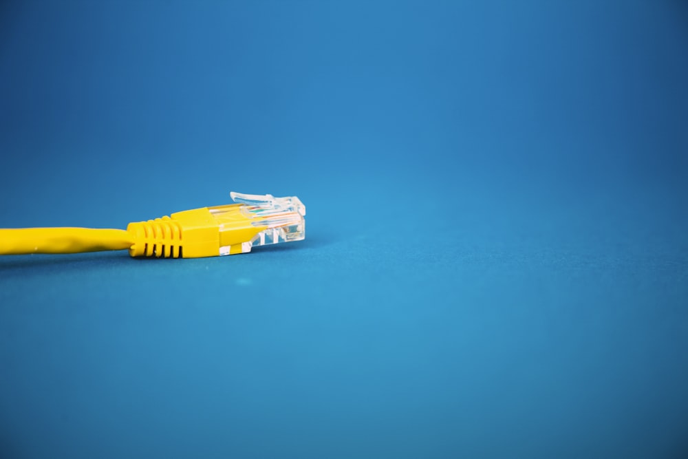 Un cable Ethernet amarillo sobre un fondo azul