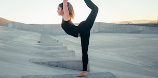 shallow focus photo of woman in black sleeveless shirt doing yoga