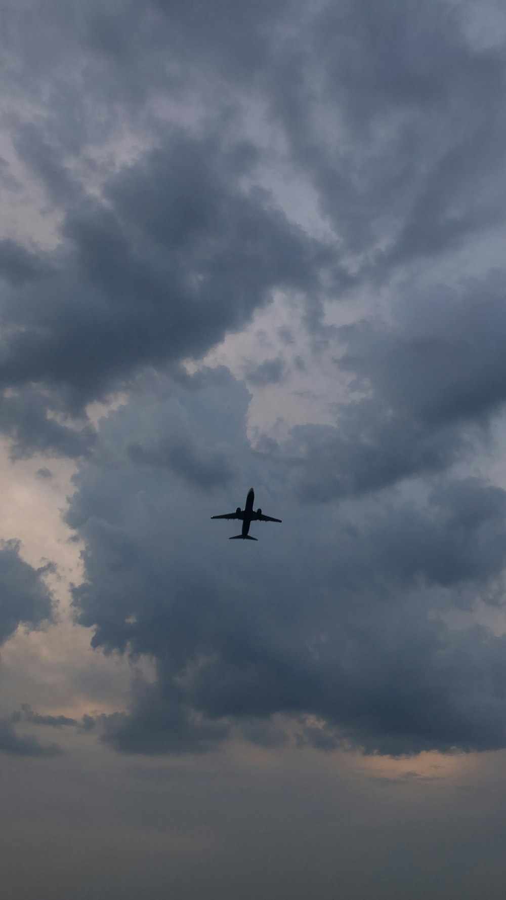 silhouette of airplane flying during daytime