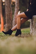 shallow focus photo of person in black booties